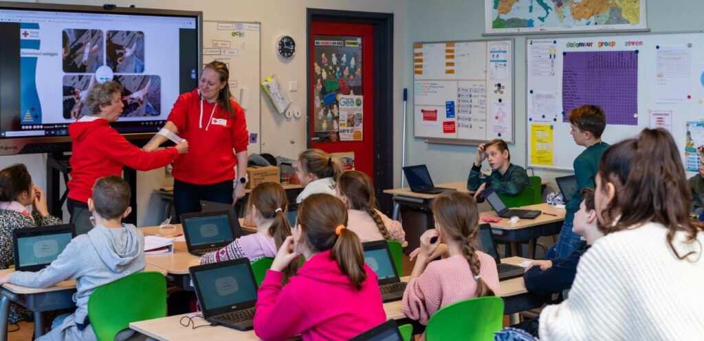 Vrijwillig Rode Kruis gastdocent geeft EHBO-gastles op basisschool