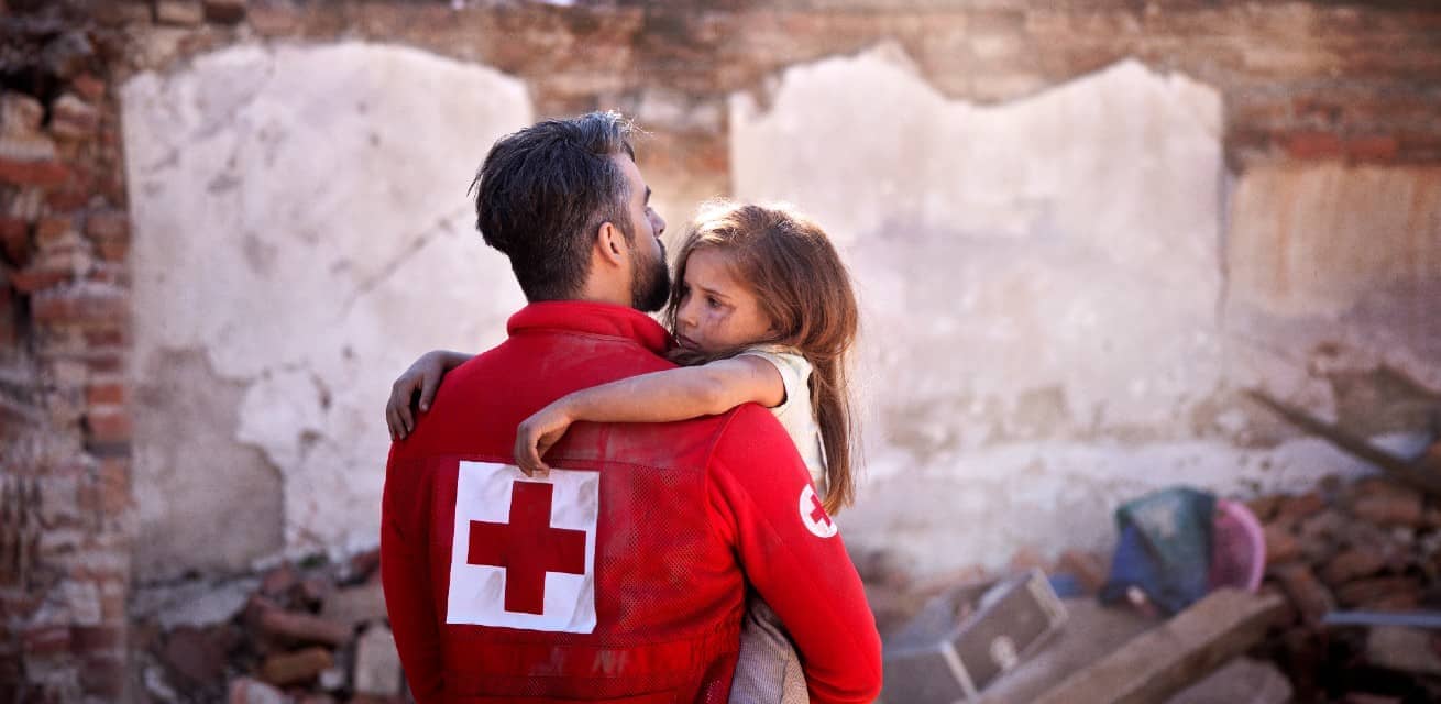 rode-kruis-vrijwilliger-helpt-meisje-na-een-aardbeving