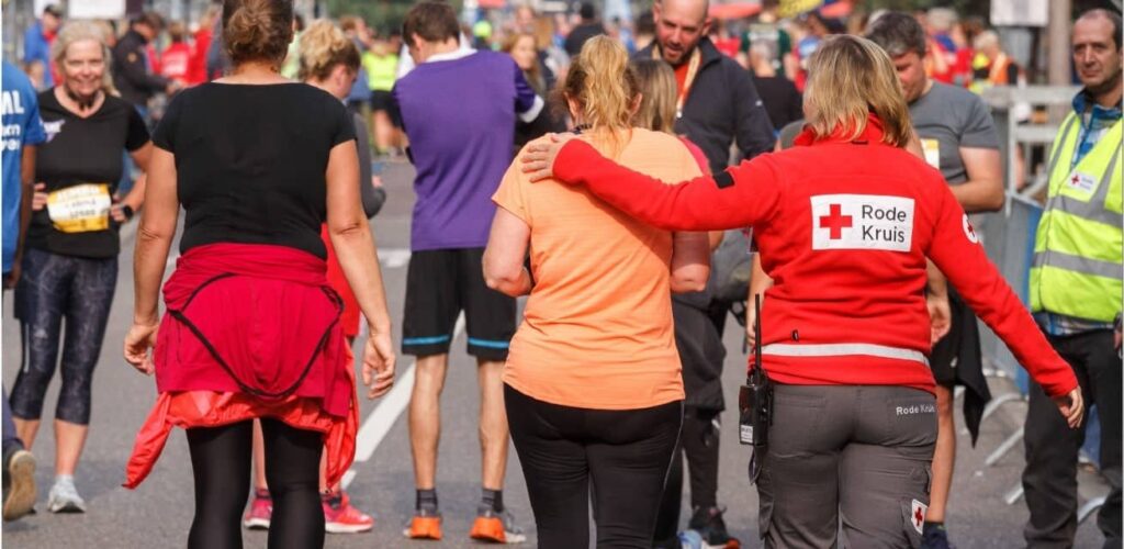 rode kruis vrijwilliger helpt bij hardloop evenement
