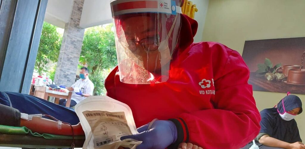 Hulpverlener helpt coronapatiënten Indonesië Rode Kruis