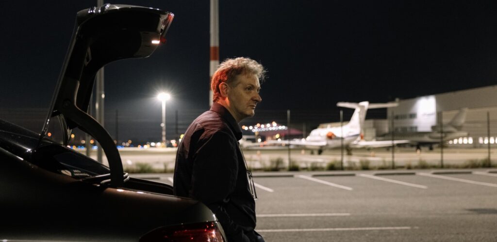 taxichauffeur Marko wacht op de luchthaven voor een klant Rode Kruis