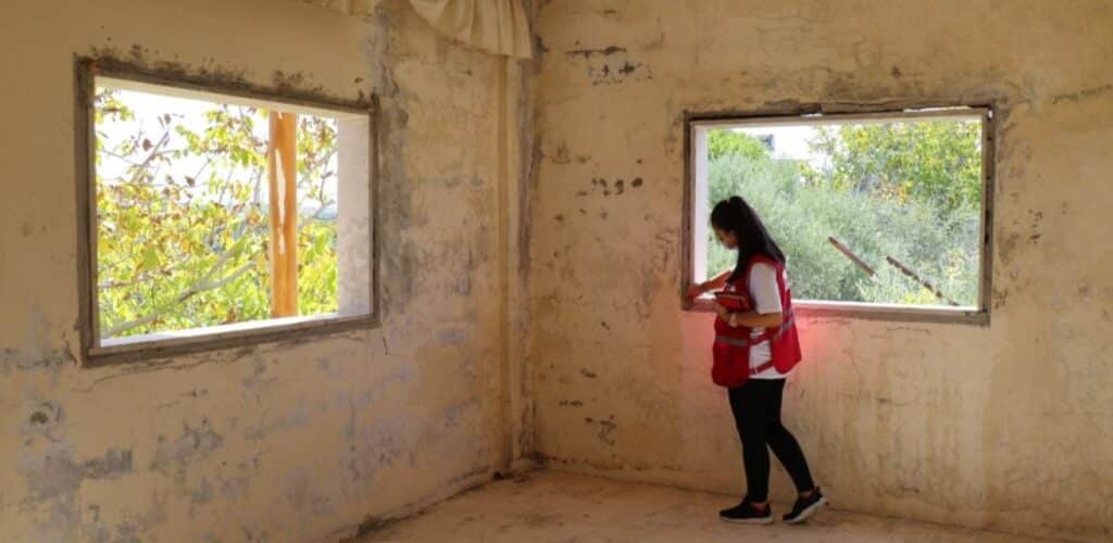 hulpverlener van Syrische Rode Halve Maan helpt bij het opknappen van huizen Rode Kruis