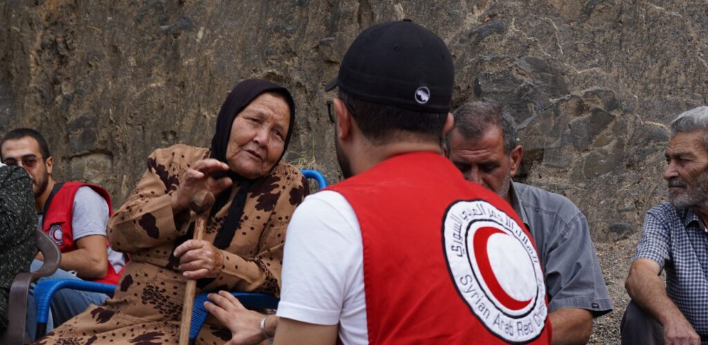 Rode Halve Maan-hulpverlener praat met mensen in Syrië Rode Kruis