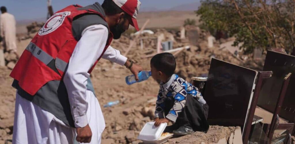 Hulpverlener Rode Kruis verleent hulp aan slachtoffers aardbeving Afghanistan 2023