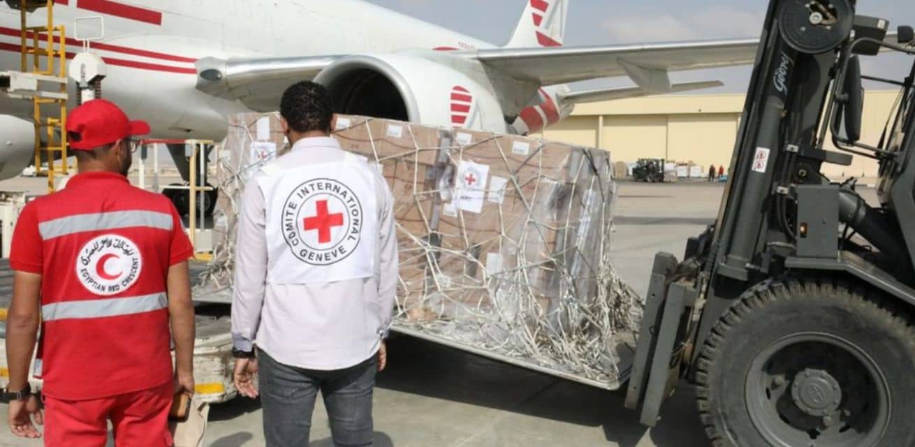 Hulpverleners van het Rode Kruis laden hulpgoederen uit die naar Gaza gaan