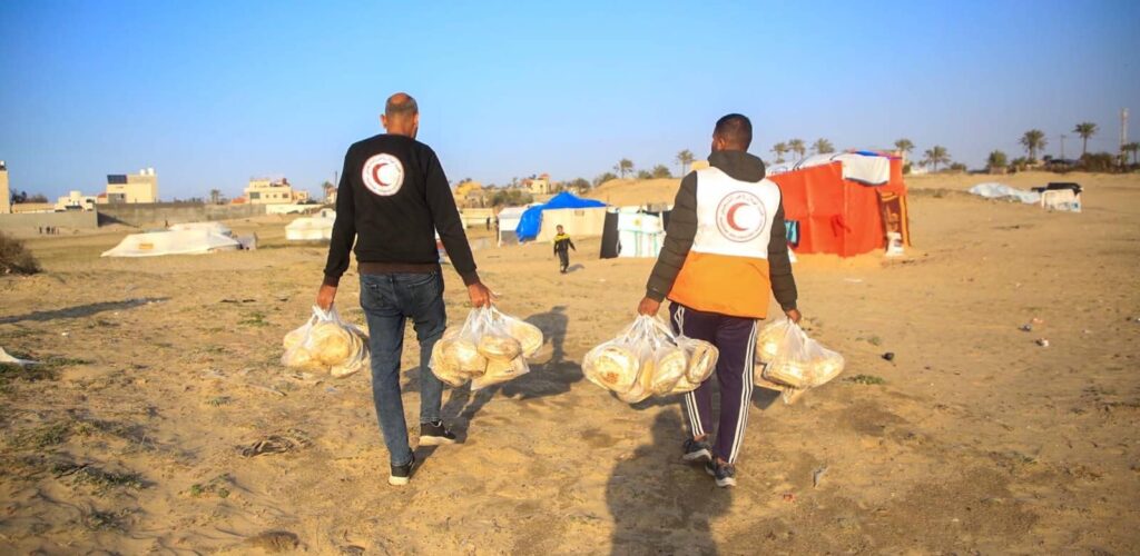 hulp aan gaza twee mannen halen voedsel rode kruis