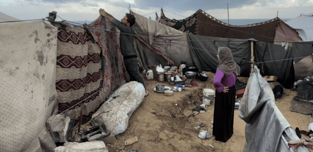 November 2025, Gaza. Door de hevige regenbuien staan tentenkampen onder water. Modder stroomt tussen de tenten door en maakt het leven voor gezinnen nog zwaarder.