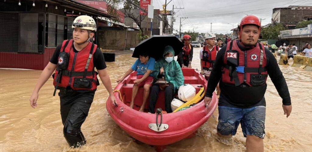 Hulpverleners van het Rode Kruis varen met boten om mensen te redden
