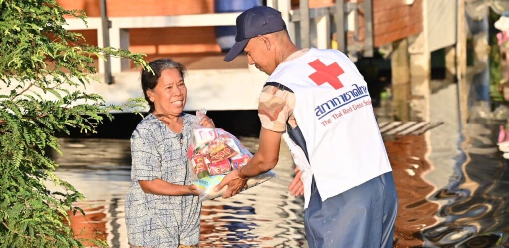 Hulpverleners van het Rode Kruis in Thailand varen met boten door de overstroomde gebieden, om zo hulppakketten uit te delen aan mensen die getroffen zijn door de overstromingen