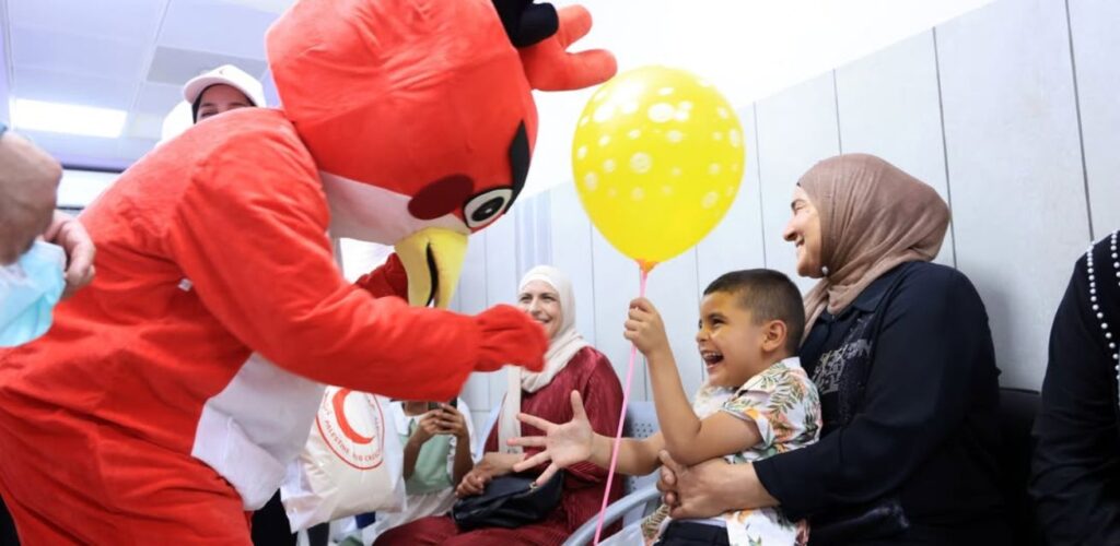 Rode Kruis vrijwilligers helpen kinderen in Gaza hun zorgen tijdelijk te ontnemen.