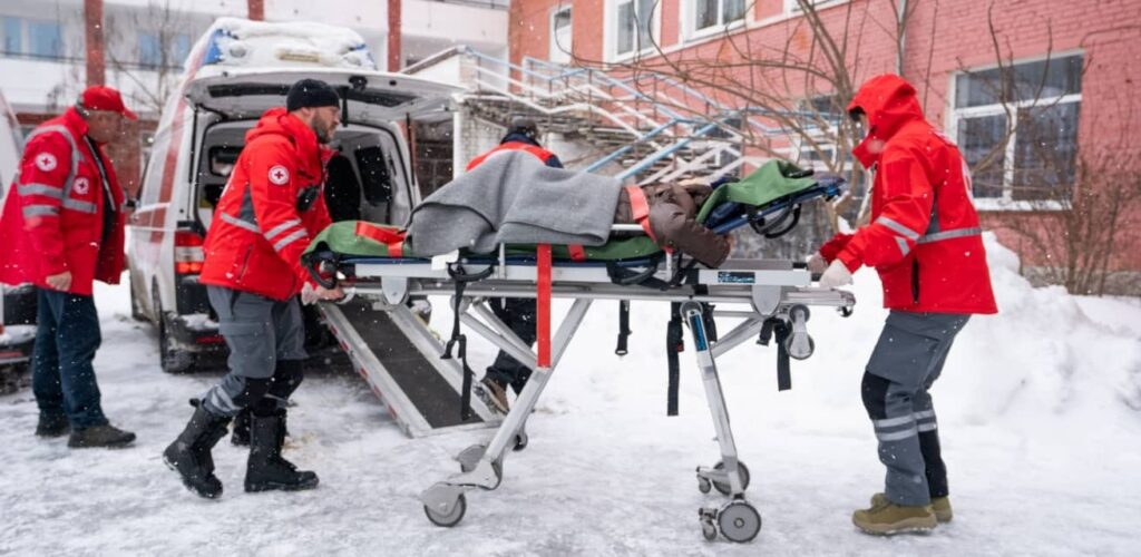 Hulpverleners van het Rode Kruis in Oekraïne helpen gewonde op brancard.