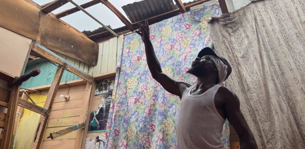Inwoner Jamaica laat schade aan huis zien na orkaan Melissa aan medewerker Rode Kruis