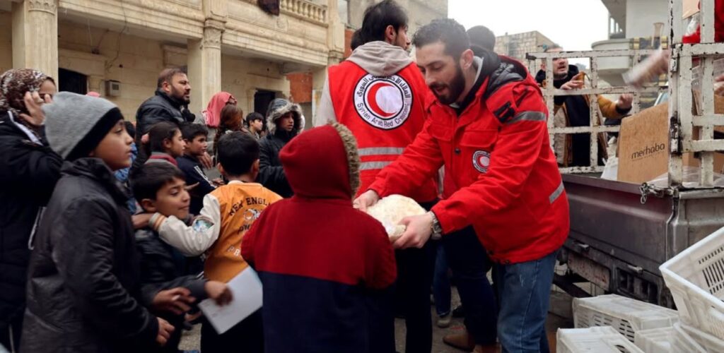 Hulpverleners van Rode Halve Maan in Syrië delen basisbenodigdheden uit.