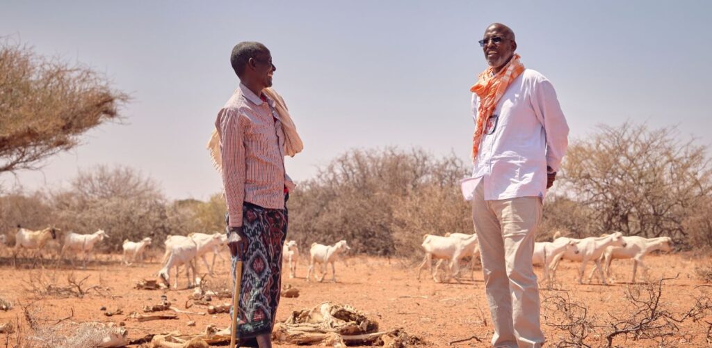 Een hulpverlener van Rode Kruis is in gesprek met boeren die getroffen worden door de extreme droogte.