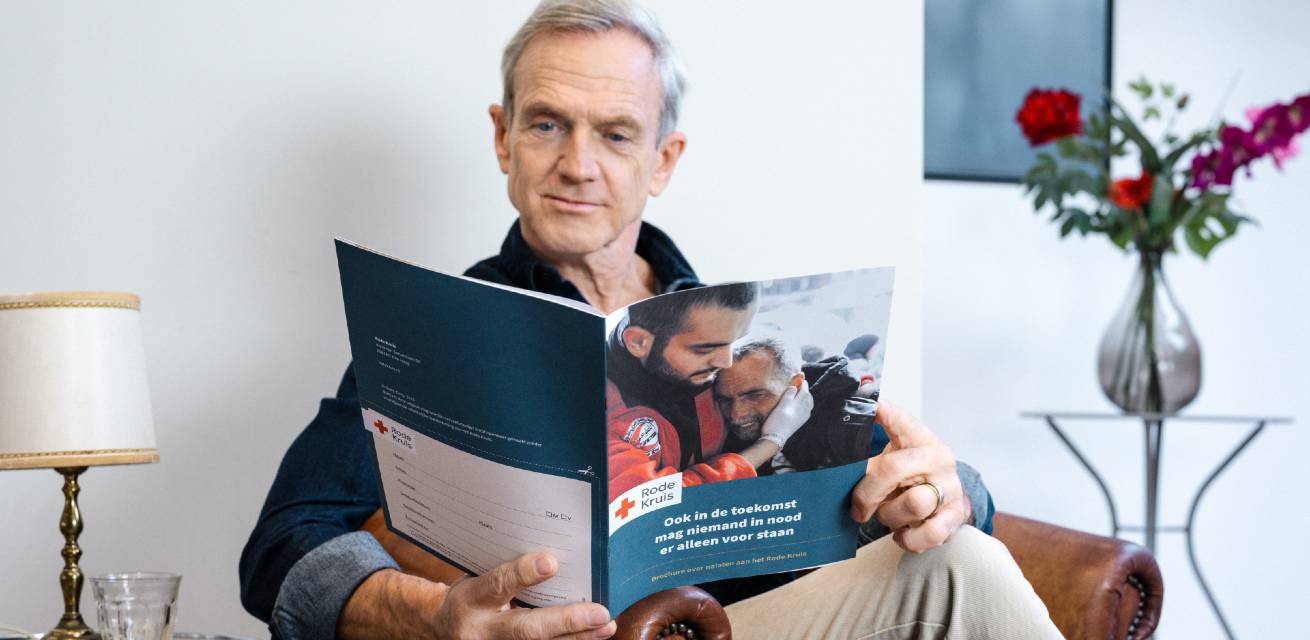 Jaap Jongbloed met brochure nalaten Rode Kruis
