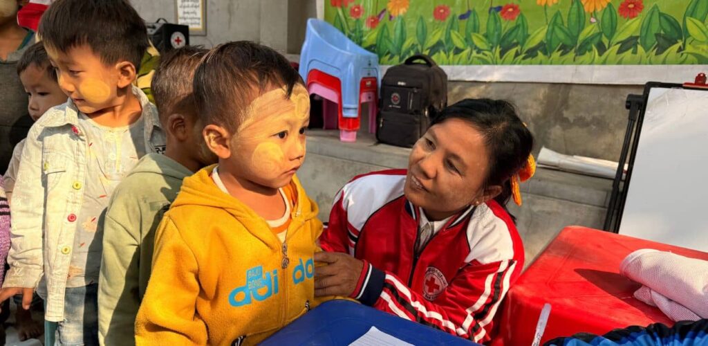 hulpverleners van het Rode Kruis in Myanmar geven psychosociale ondersteuning aan kinderen na aardbeving 2025