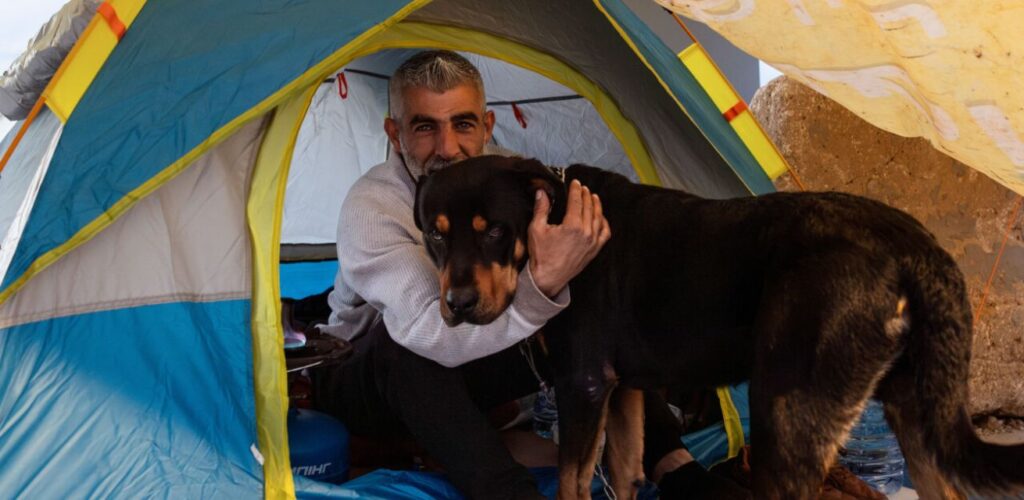 Zaher met zijn hond in een tijdelijke tent. Foto: Foto: Toufic Rmeiti