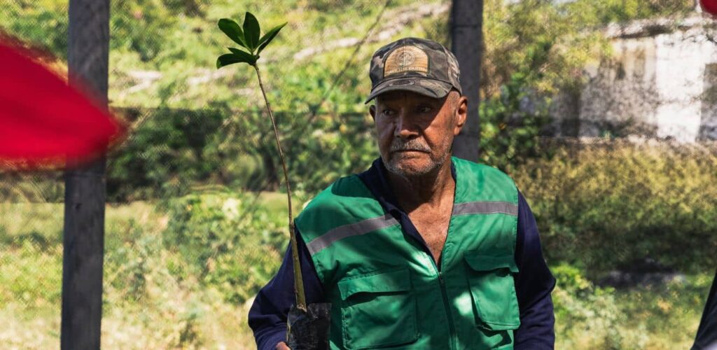 Euclides vrijwilliger Rode Kruis in Colombia laat mangrove plant zien