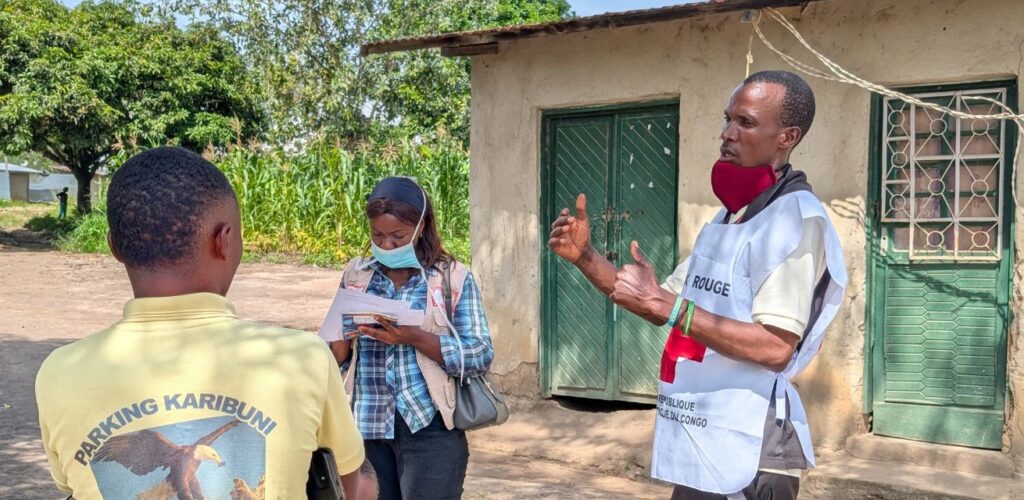 Hulpverlener van het Rode Kruis gaat langs de deuren om voorlichting te geven over Ebola