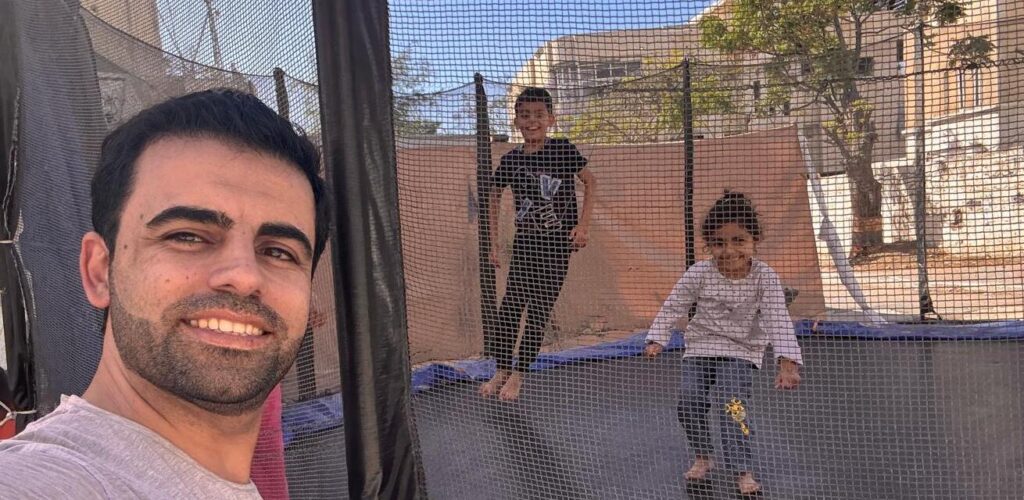Amr en zijn kinderen op de trampoline Rode Kruis