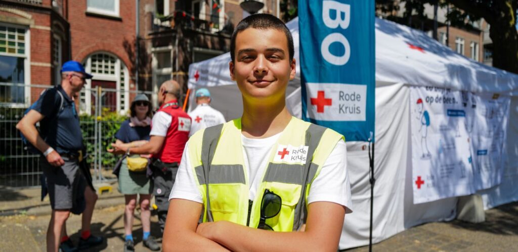 De jongste vrijwilliger, Eray (14), staat bij de EHBO-post klaar om mensen te helpen.