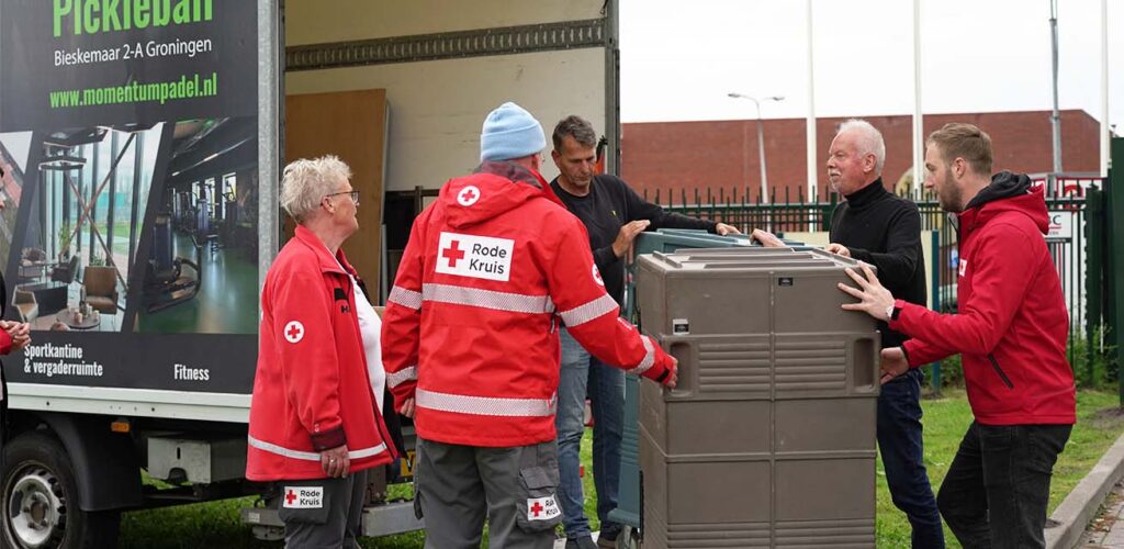 Hulpverleners van het Rode Kruis zetten alles klaar om hulp te verlenen aan mensen die wachten voor het aanmeldcentrum in Ter Apel