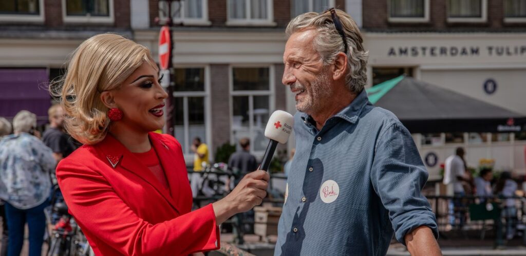 Dragqueen Envy Peru in gesprek met een voorbijganger in Amsterdam over vooroordelen.