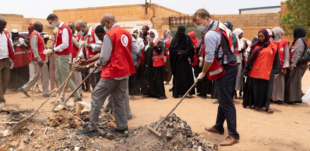 Derk Segaar (rechts) neemt deel aan een community clean-up georganiseerd door de Soedanese Rode Halve Maan