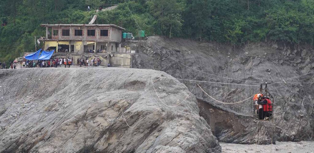 Mensen kunnen in Nepal de rivier over via een tijdelijke kabelverbinding