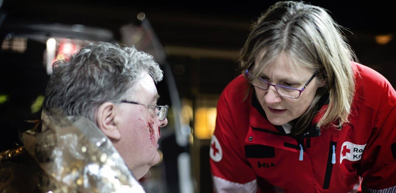 rode kruis ehbo vrijwilliger helpt gewonde man